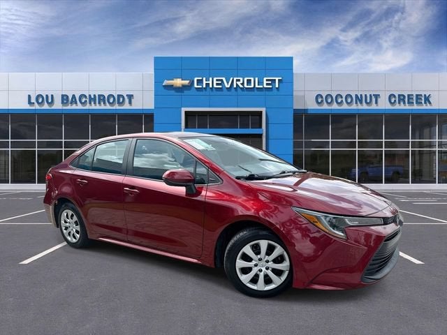 2024 Toyota Corolla LE in Ruby Flare Pearl — front three-quarter view